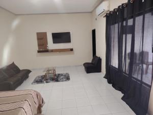 a living room with a couch and a tv on a wall at SKk in Warnes