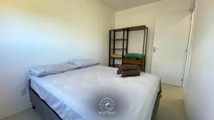 um pequeno quarto com uma cama e um espelho em Apto aconchegante | 04 pessoas | em Passo de Torres em Passo De Torres