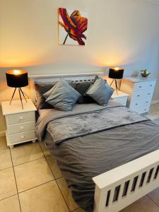 a bedroom with a bed with two night stands and two lamps at Large Room Near City Centre in Belfast