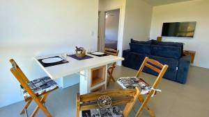 uma sala de estar com uma mesa e cadeiras e um sofá azul em Apto aconchegante | 04 pessoas | em Passo de Torres em Passo De Torres