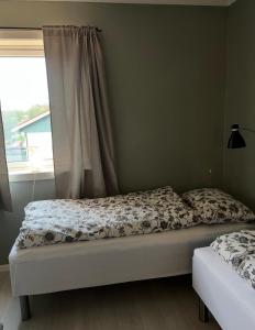 two beds in a bedroom with a window at Wonderful Seaview Apartment in Tromsø