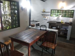 eine Küche mit einem Holztisch und Stühlen in einem Zimmer in der Unterkunft Sinta-se em casa in Alto Paraíso de Goiás