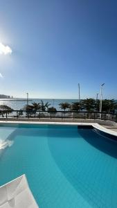 a large swimming pool with the ocean in the background at 1506 - Blue Tree Towers in Fortaleza