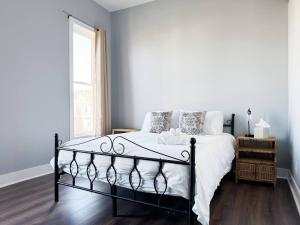 a bedroom with a bed with white sheets and a window at The Washington Apartments in Evansville