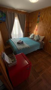 a bedroom with a bed and a red suitcase at Habitación Rocas del mar in Pichilemu