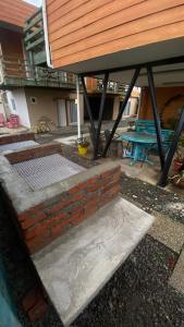 a patio with a table and a brick wall at Habitación Rocas del mar in Pichilemu