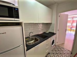 Una pequeña cocina con fregadero y microondas. en Lindo estudio en Martiánez, en Puerto de la Cruz