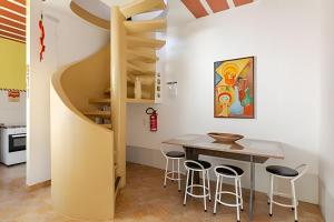 贝洛奥里藏特Pampulha Guest House - Mineirão, Lagoa e UFMG a pé的厨房设有木桌和木制螺旋楼梯。 更多48张照片