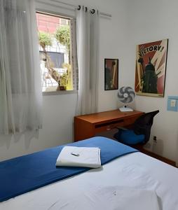 贝洛奥里藏特Pampulha Guest House - Mineirão, Lagoa e UFMG a pé的一间卧室，配有一张床、一张书桌和一扇窗户