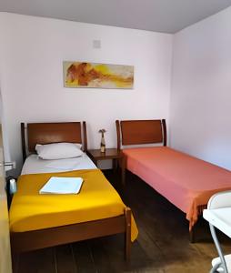 贝洛奥里藏特Pampulha Guest House - Mineirão, Lagoa e UFMG a pé的配有两张黄色和红色床单的床铺