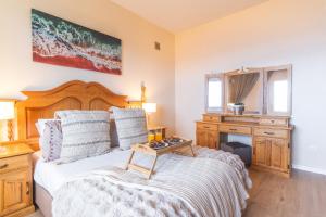 een slaapkamer met een groot bed met een houten hoofdeinde bij Villa Mar by Atlantic Holiday in Porto Moniz