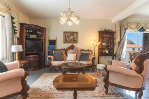 een woonkamer met meubilair en een kroonluchter bij Villa Mar by Atlantic Holiday in Porto Moniz