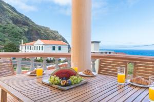 een tafel met een bord eten en sinaasappelsap bij Villa Mar by Atlantic Holiday in Porto Moniz