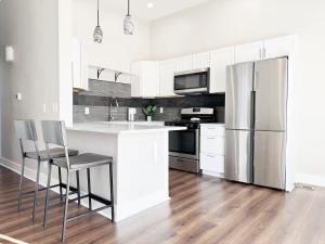 a kitchen with white cabinets and a stainless steel refrigerator at The Washington Apartments in Evansville
