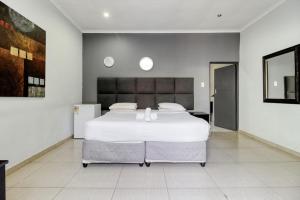 ヨハネスブルグにあるHunni Hotel Melrose Edgeの部屋にある大きな白いベッドのある寝室