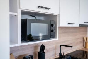 a microwave in a cabinet in a kitchen at Luxapartment l Krivá in Košice +6 photos