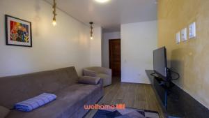 a living room with a couch and a flat screen tv at Chale em Serra Negra com vista para montanha in Bezerros +25 photos