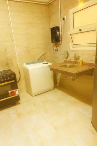 eine kleine Küche mit Spüle und Kühlschrank in der Unterkunft Apartment, New Administrative Capital in Madīnat al Amal