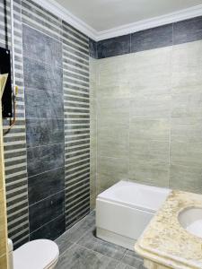 ein Badezimmer mit Badewanne, Toilette und Waschbecken in der Unterkunft Apartment, New Administrative Capital in Madīnat al Amal