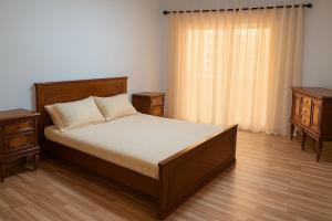 ein Schlafzimmer mit einem Bett mit zwei Nachttischen und einem Fenster in der Unterkunft Apartment, New Administrative Capital in Madīnat al Amal