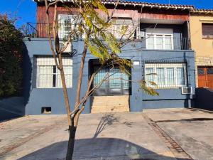 a small tree in front of a blue house at Costa de Tigre, habitaciones in Tigre