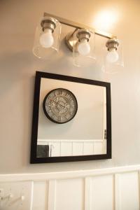 a mirror on a shelf with a clock and lights at 718 Morgan Ave in Harriman +43 photos