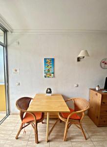 Una mesa y sillas de madera en una habitación. en Cozy studio in Martianez, en Puerto de la Cruz