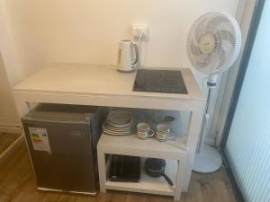 a small table with a coffee maker and a fan at Home Estudio 3 in Santiago