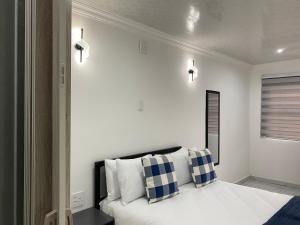 a bedroom with a bed with blue and white pillows at The Palms Guest House in Johannesburg +65 photos