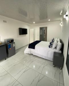 a bedroom with a bed and a tv on the wall at The Palms Guest House in Johannesburg