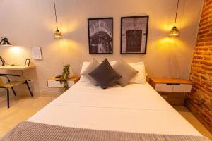 une chambre avec un lit blanc avec deux tableaux au mur dans l'établissement Hotel Casa Agena, à Carthagène des Indes 71 autres photos