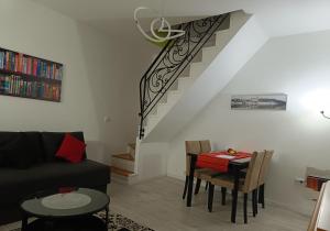 a living room with a table and a staircase at Zemun Central in Zemun