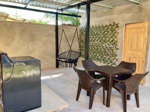 a patio with a table and chairs and a grill at Joy & peace house in Tela