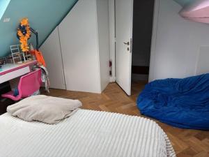 a bedroom with a bed and a desk and a door at Stay in maison de metre in Etterbeek in Brussels