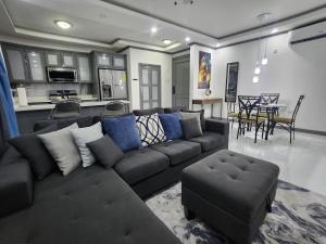 a living room with a large couch and a kitchen at Modern Kingston Condo with Rooftop Pool and View in Kingston