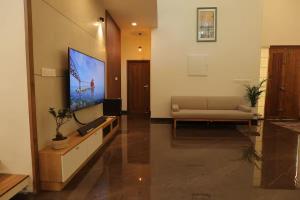 a living room with a couch and a flat screen tv at Mon Reve Holidays in Kozhikode