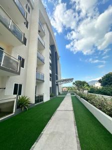 an apartment building with a green lawn at Modern Kingston Condo with Rooftop Pool and View in Kingston