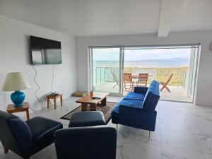 a living room with a blue couch and chairs at Pyramid beach house in Karikari Peninsula