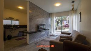 a living room with a couch and a fireplace at Chale em Serra Negra vista para montanha e lareira in Bezerros