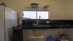 a kitchen counter with a sink and a window at Chale em Serra Negra vista para montanha e lareira in Bezerros +24 photos