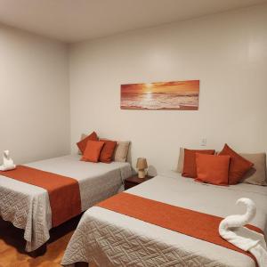a room with two beds and a swan on the wall at Hotel Hacienda Casa del Viento in Cuajiniquil