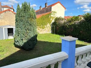 a bush sitting next to a white railing next to a house at Maison moderne avec jardin espace télétravail in Bobigny