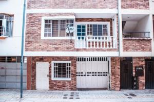 a brick building with white doors and a balcony at EquiNox Central House Bucaramanga in Bucaramanga