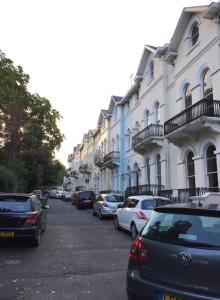 una fila de coches estacionados frente a los edificios en Spacious Garden Flat in Cheltenham, en Moffat