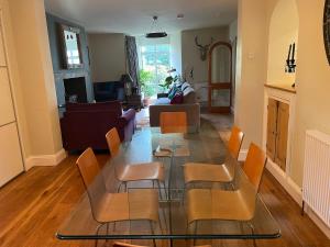 a living room with a glass table and chairs at Spacious Garden Apartment in Cheltenham in Cheltenham