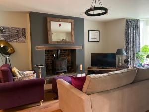 Una sala de estar con un sofá y una chimenea. en Spacious Garden Flat in Cheltenham, en Moffat