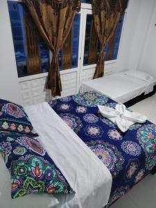 two beds sitting in a room with windows at Hotel Paris Mirador in Garzón
