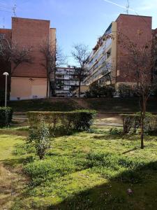 a park in front of a building with trees and bushes at Loft Nórdico Madrid Aguilafuente in Madrid