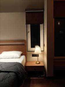 a bedroom with a bed and a lamp on a table at Evara - stay explore belong in Varanasi