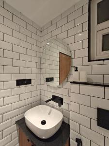 a white bathroom with a sink and a mirror at Evara - stay explore belong in Varanasi